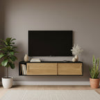 Modern living room with a wooden TV stand, television, and decorative plants.