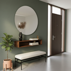 Modern interior with a round mirror, wooden shelf, and bench against a green wall.