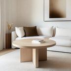 Minimalist white oak coffee table with a sturdy base and smooth, rounded edges, sitting in a sophisticated living area with warm earthy accents.
